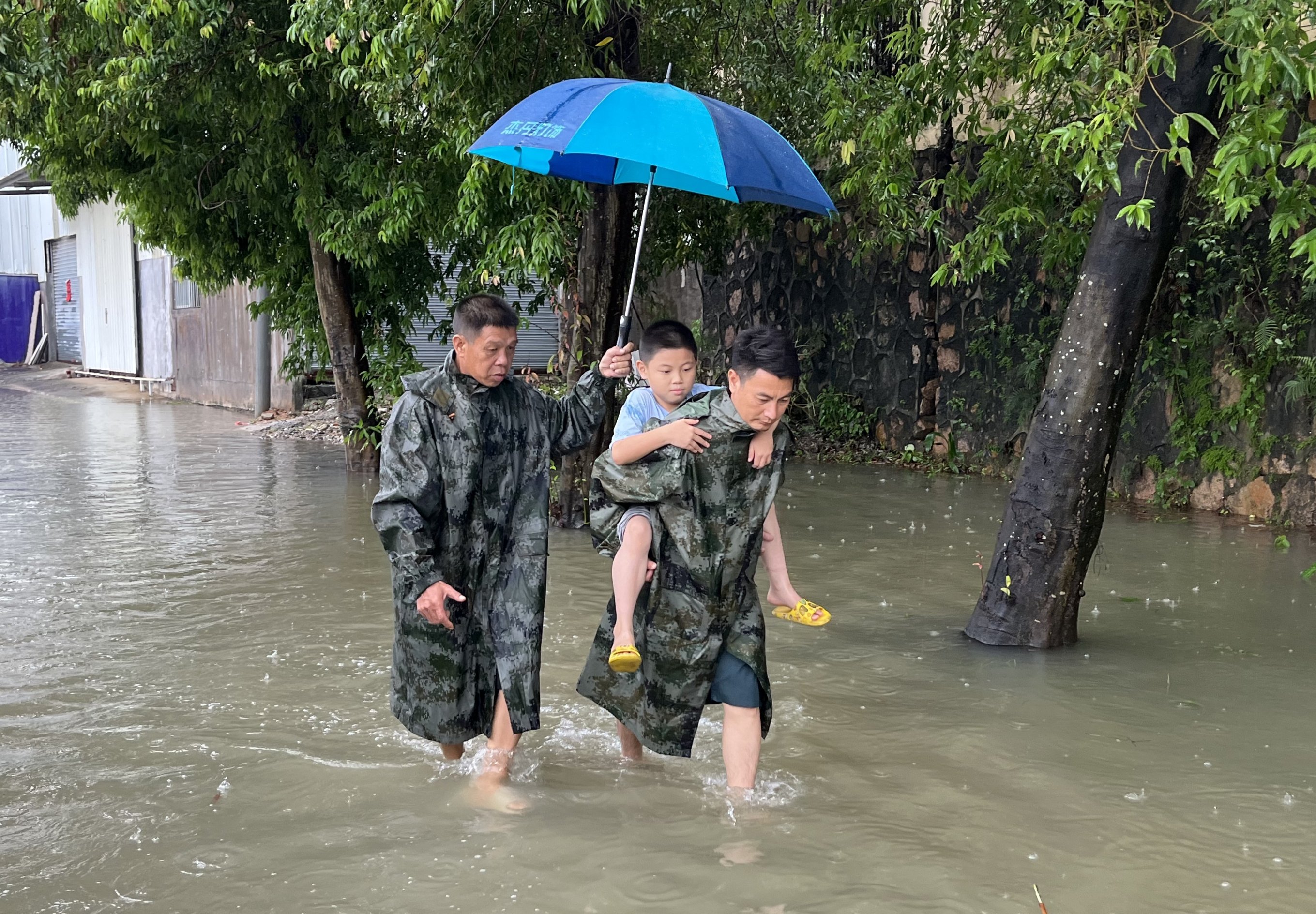 中山市三鄉(xiāng)鎮(zhèn)泉眼村內(nèi)多處發(fā)生水浸，退役軍人和消防站隊(duì)員共同護(hù)送小男孩回家。何家鑫攝