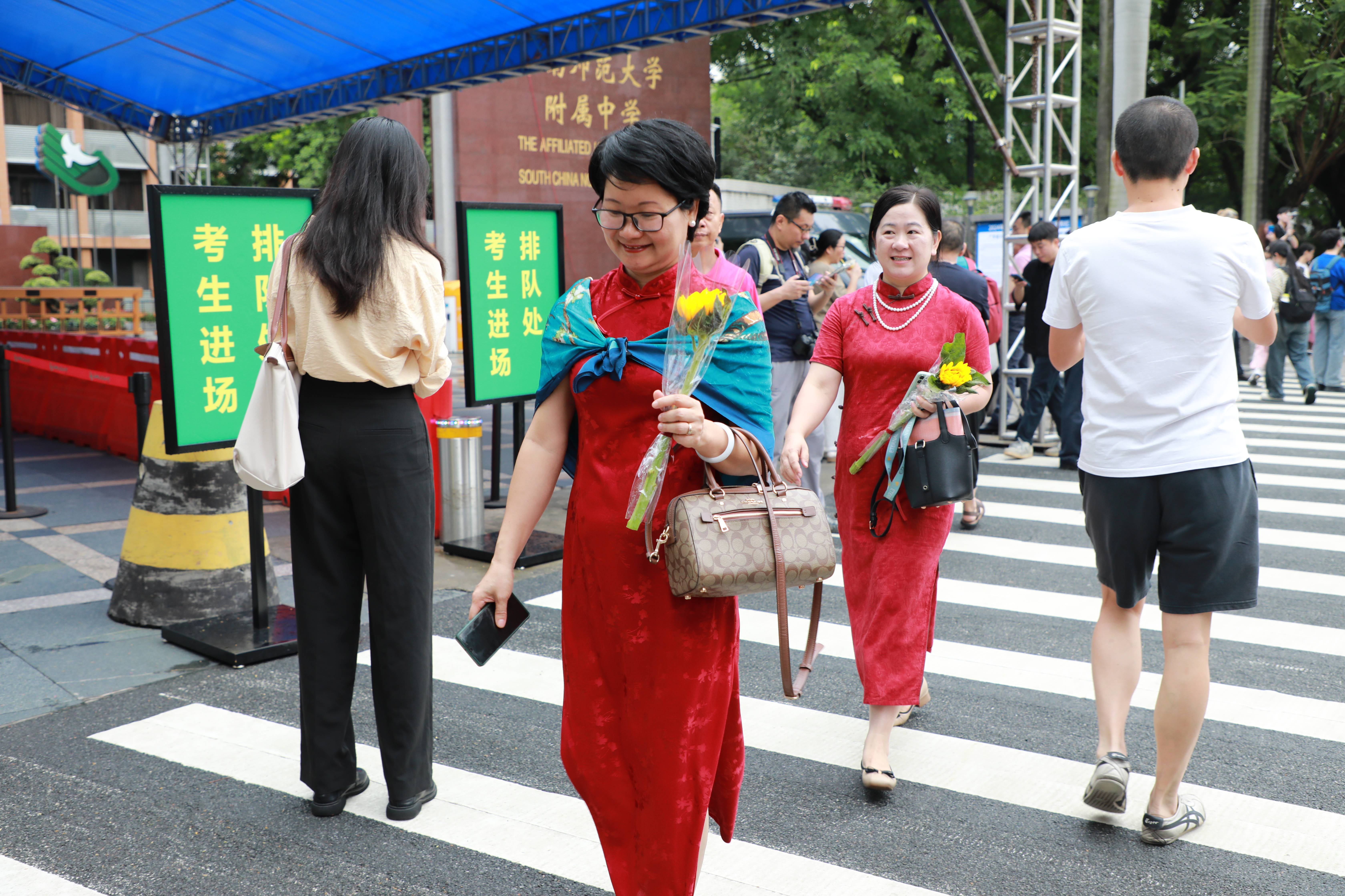 高考首日，廣東考生家長身穿旗袍，手拿向日葵，寓意“旗開得勝”“一舉奪魁”！人民網(wǎng) 寧玉瑛攝